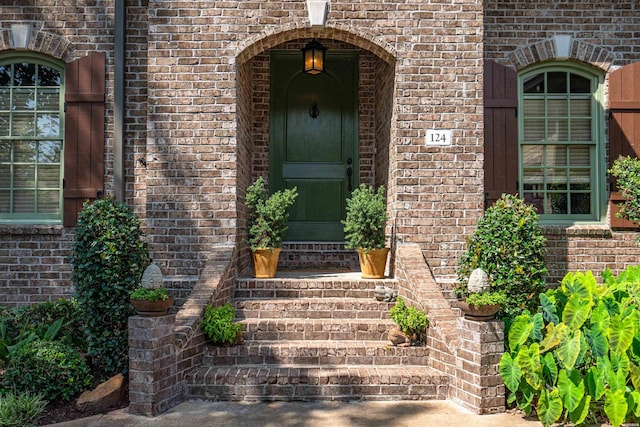 view of exterior entry featuring brick siding