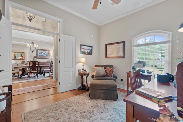 office featuring ceiling fan with notable chandelier, ornamental molding, wood finished floors, and baseboards