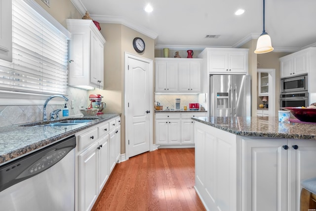 kitchen featuring a sink, visible vents, white cabinetry, hanging light fixtures, and appliances with stainless steel finishes