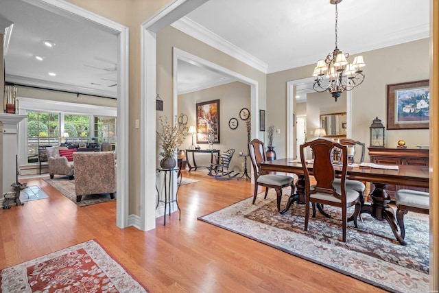 dining area featuring a chandelier, light wood-type flooring, and crown molding