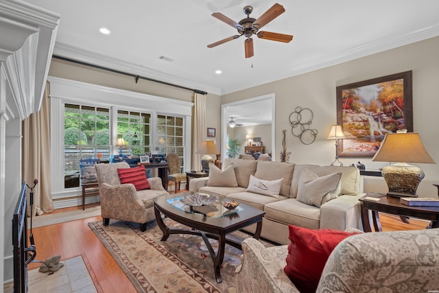 living room featuring recessed lighting, visible vents, ornamental molding, a ceiling fan, and light wood-type flooring