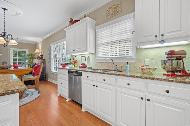 kitchen with pendant lighting, crown molding, white cabinets, a sink, and dishwasher