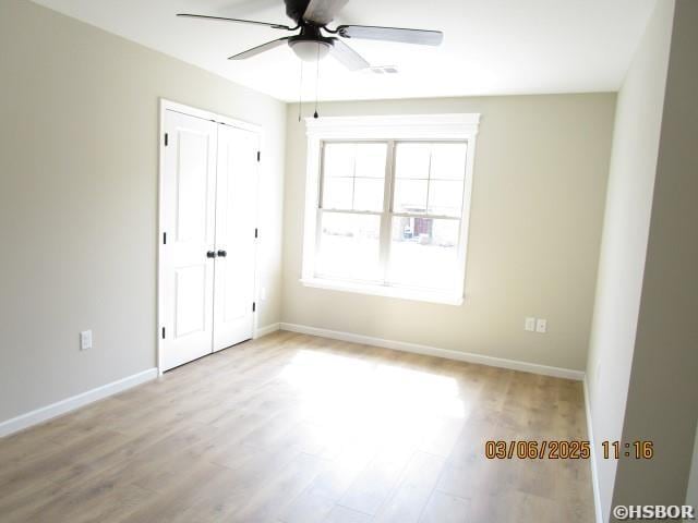 spare room with ceiling fan, baseboards, and wood finished floors