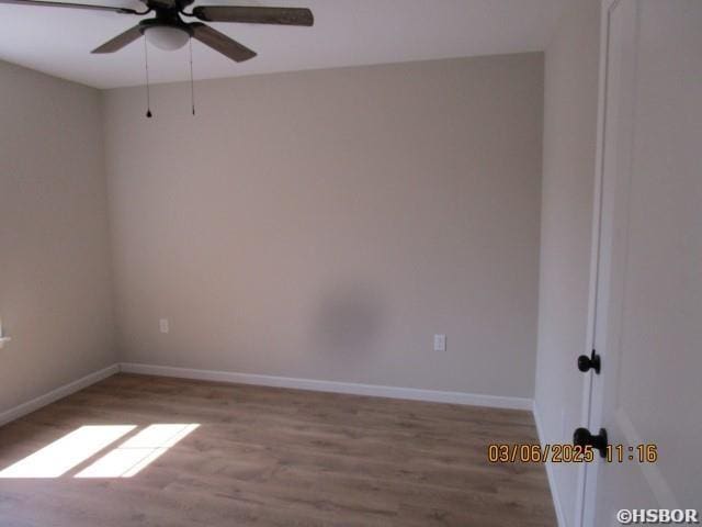 spare room with ceiling fan, baseboards, and wood finished floors