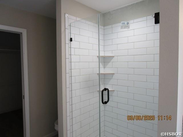 bathroom with toilet and a stall shower