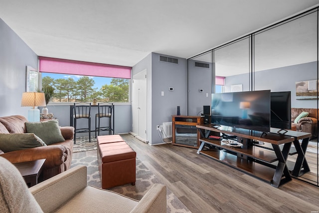 living area featuring visible vents and wood finished floors