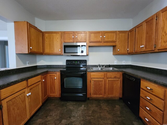 kitchen featuring dark countertops, brown cabinets, a sink, and black appliances