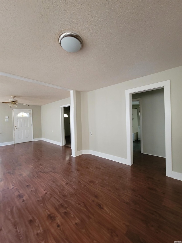 interior space with ceiling fan, dark wood-style flooring, a textured ceiling, and baseboards