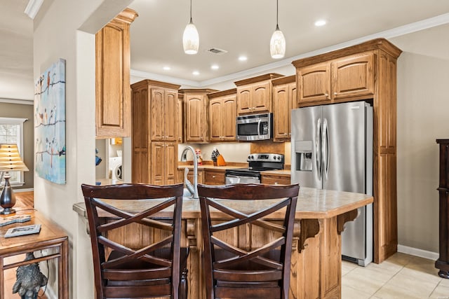 121 Wildwood Forest Rd, Hot Springs, AR 71913 - kitchen featuring a kitchen bar, hanging light fixtures, stainless steel appliances, visible vents, and washer and dryer