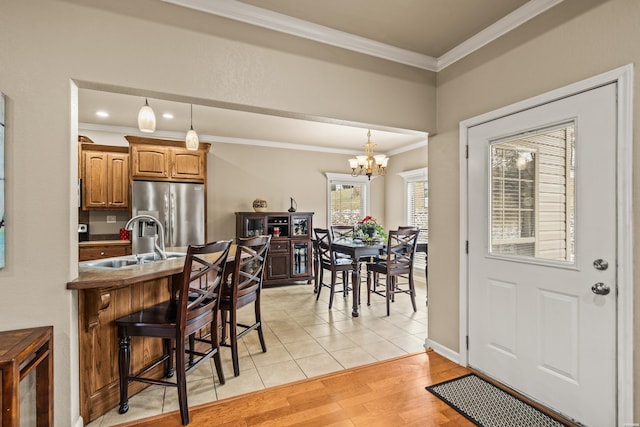 121 Wildwood Forest Rd, Hot Springs, AR 71913 - kitchen featuring a sink, a breakfast bar area, stainless steel fridge, light wood-style flooring, and an inviting chandelier