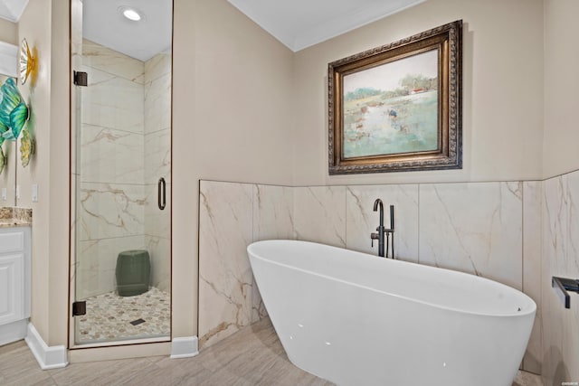 full bath with a marble finish shower, a freestanding bath, and vanity