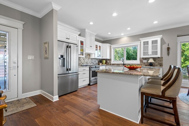 kitchen featuring white cabinets, glass insert cabinets, appliances with stainless steel finishes, dark wood-type flooring, and light stone counters