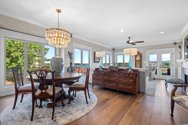 dining space with ornamental molding, light wood-type flooring, and a fireplace