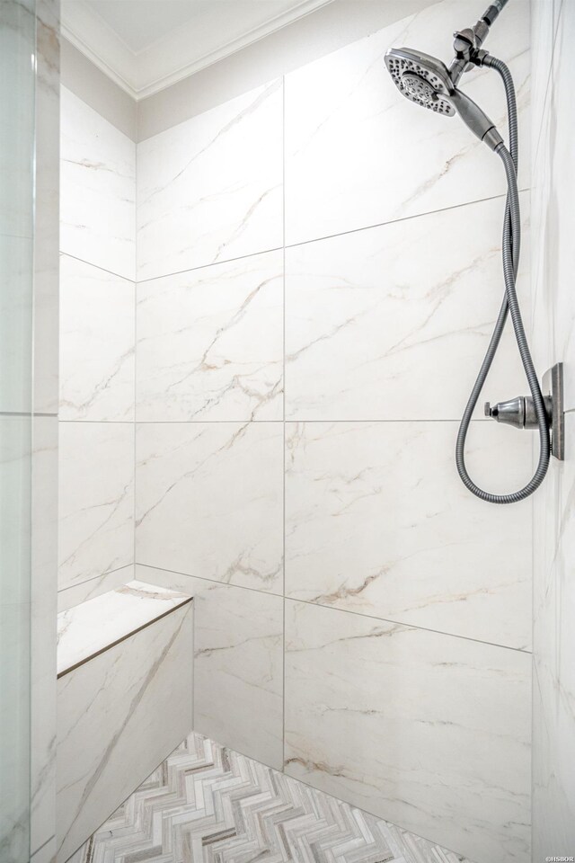 full bath with ornamental molding and a tile shower