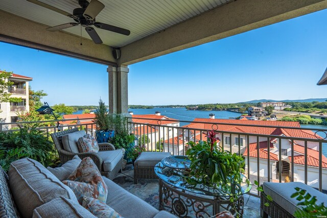 balcony with a ceiling fan, a water view, and outdoor lounge area