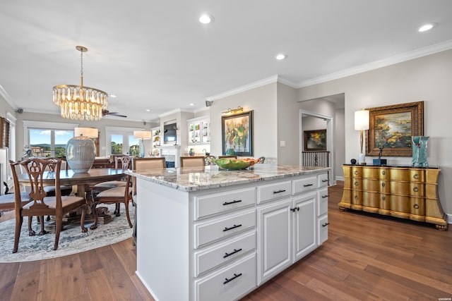 kitchen featuring dark wood-style floors, decorative light fixtures, open floor plan, white cabinets, and a kitchen island