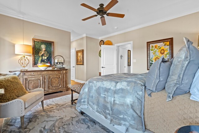 bedroom featuring ornamental molding, light wood-style floors, baseboards, and a ceiling fan