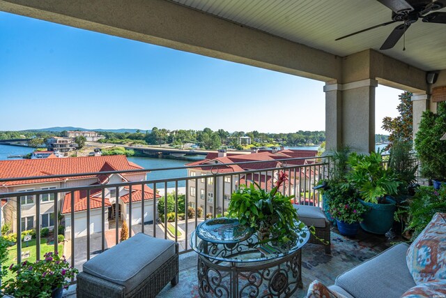 balcony featuring a water view and a ceiling fan