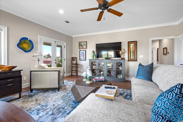 living room with ornamental molding, wood finished floors, and baseboards