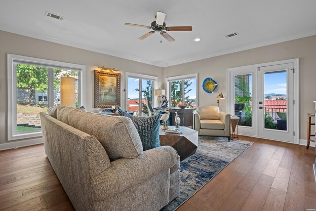 living room featuring light wood-type flooring, visible vents, and a ceiling fan