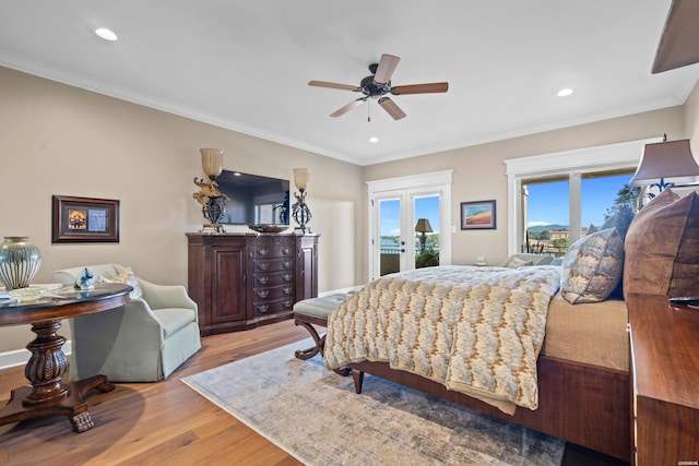 bedroom featuring light wood-style floors, access to outside, crown molding, and french doors