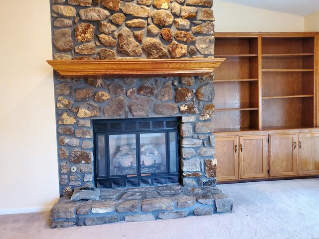 details featuring carpet floors, a stone fireplace, and baseboards