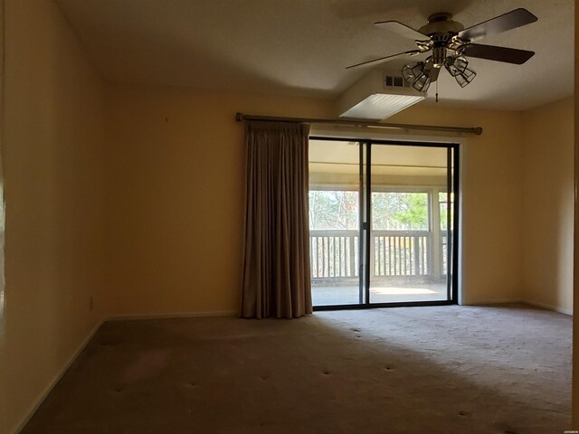 carpeted spare room with visible vents, baseboards, and a ceiling fan