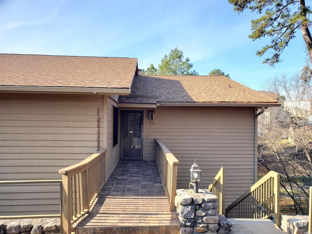 doorway to property featuring a shingled roof