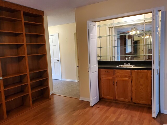 bathroom with ceiling fan, a sink, baseboards, and wood finished floors