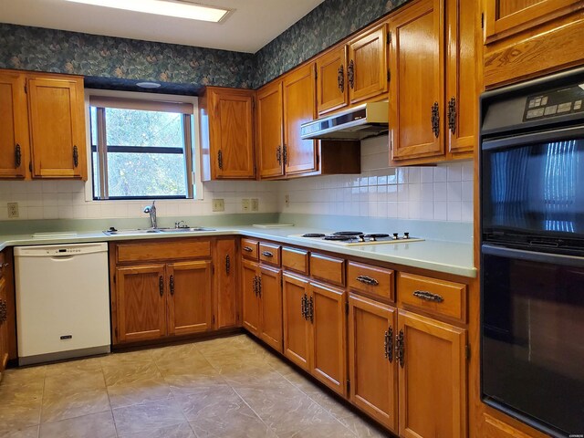 kitchen with light countertops, white appliances, a sink, and under cabinet range hood