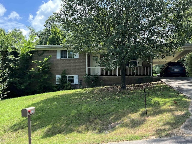 view of front of house with an attached carport, concrete driveway, brick siding, and a front lawn