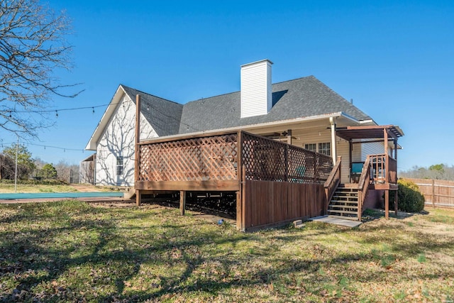 back of house with a chimney, stairway, a lawn, and a wooden deck