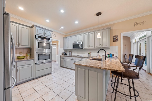 kitchen with gray cabinetry, a peninsula, a sink, appliances with stainless steel finishes, and crown molding