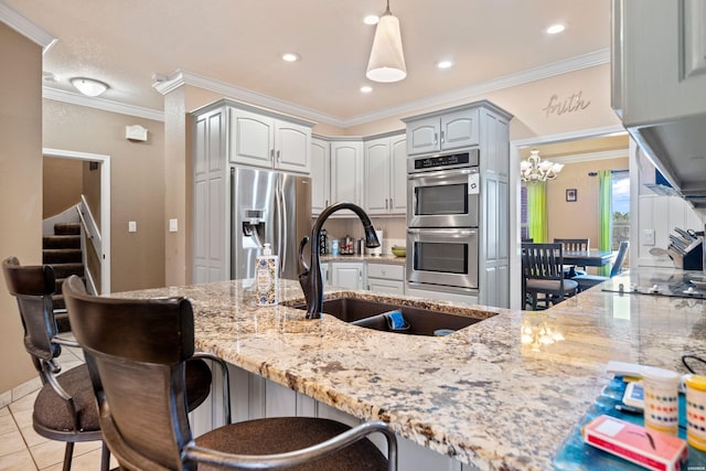 kitchen with light stone counters, a breakfast bar, a sink, appliances with stainless steel finishes, and crown molding