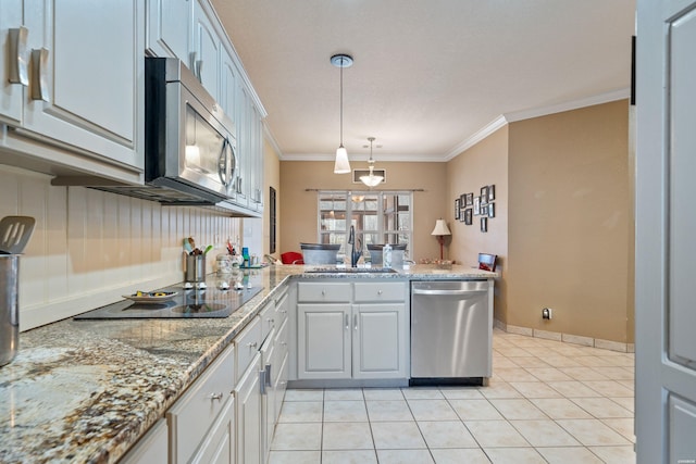 kitchen with pendant lighting, light tile patterned floors, appliances with stainless steel finishes, ornamental molding, and a sink