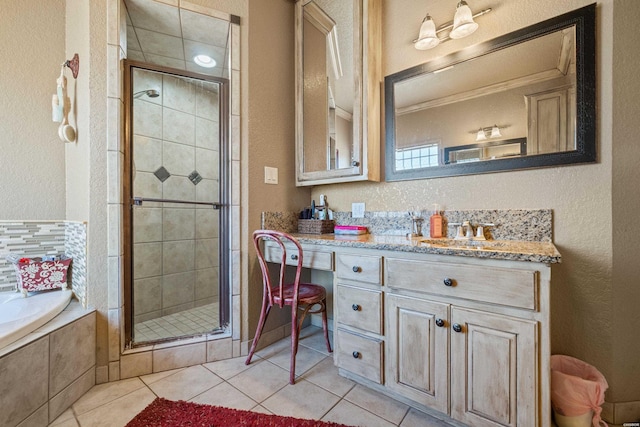 full bathroom with a textured wall, tile patterned flooring, vanity, a shower stall, and a bath