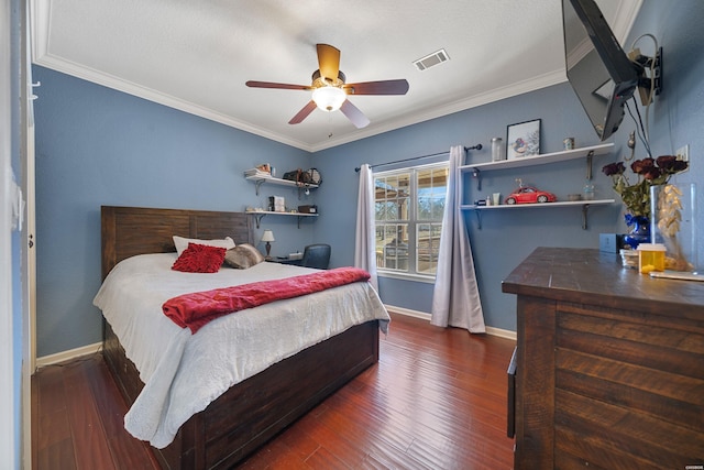 bedroom with ceiling fan, visible vents, baseboards, ornamental molding, and wood-type flooring