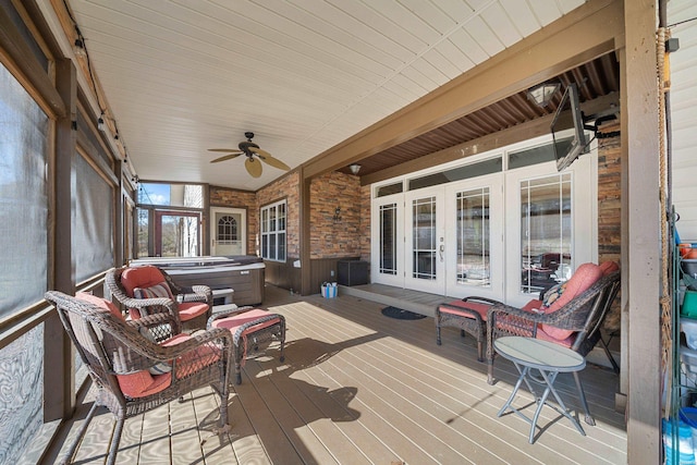 deck with french doors, ceiling fan, and a hot tub