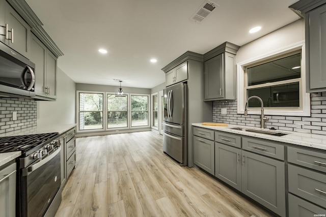 kitchen with visible vents, a sink, gray cabinets, and stainless steel appliances