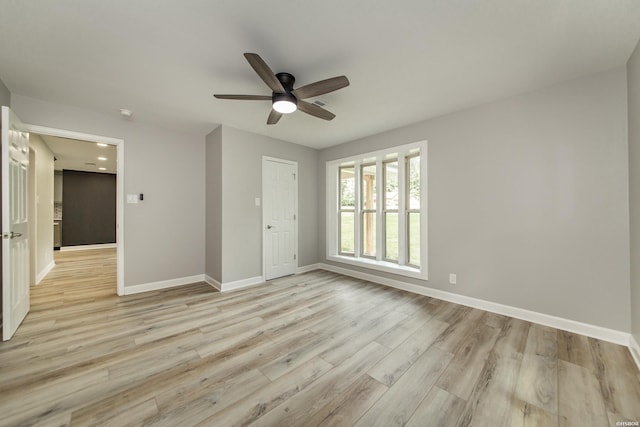 interior space with baseboards, ceiling fan, and light wood-type flooring