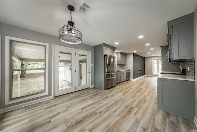 kitchen featuring visible vents, light wood finished floors, appliances with stainless steel finishes, backsplash, and gray cabinetry