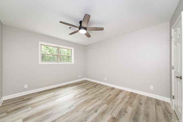 spare room featuring baseboards, light wood finished floors, and ceiling fan