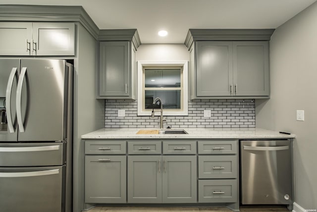 kitchen with a sink, gray cabinets, and appliances with stainless steel finishes