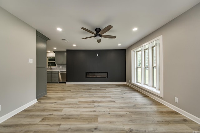 unfurnished living room featuring light wood-style flooring, a ceiling fan, baseboards, recessed lighting, and visible vents
