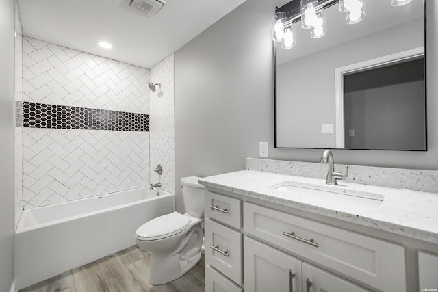 full bathroom with visible vents, wood finished floors, vanity, toilet, and bathing tub / shower combination