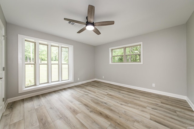 empty room featuring a ceiling fan, baseboards, a healthy amount of sunlight, and light wood-style floors