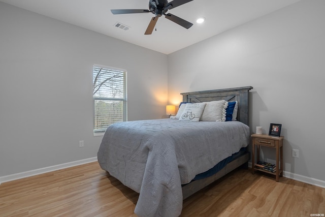 bedroom with light wood-type flooring, visible vents, and baseboards