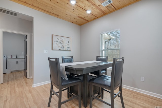 dining room with light wood-type flooring, wood ceiling, visible vents, and baseboards