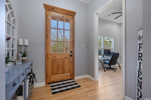 foyer with a ceiling fan, baseboards, and light wood finished floors