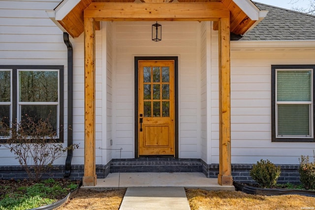 entrance to property with a shingled roof